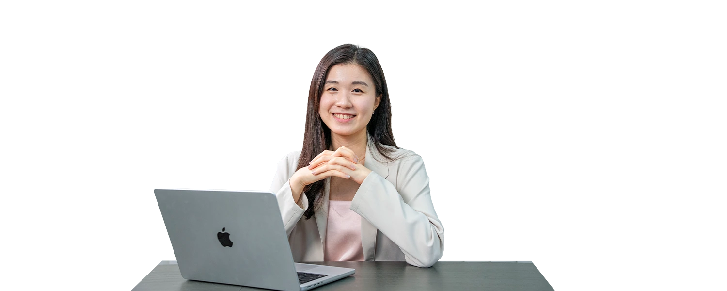 A girl with a laptop sitting in front of a table.